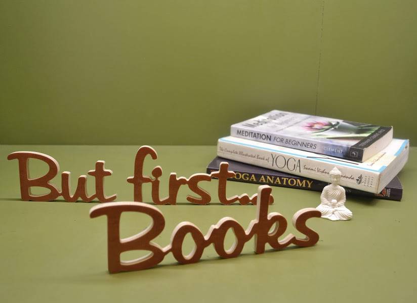 Medinis pastatomas užrašas "But first...Books"